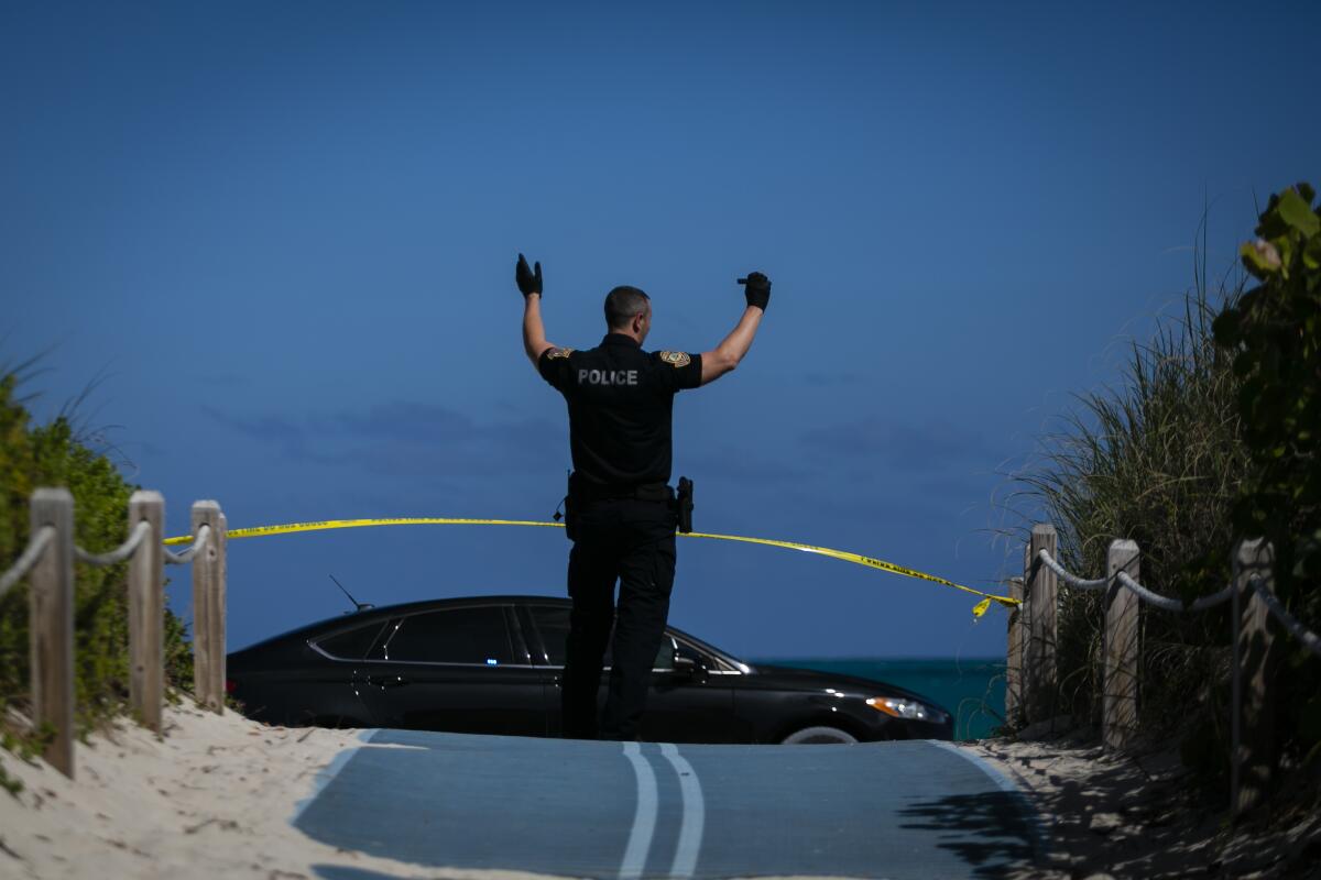 A Miami Beach police officer stands in a closed beach entrance on South Beach.