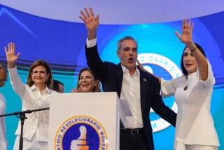 Incumbent presidential candidate Luis Abinader, center, waves to supporters alongside vice presidential candidate Raquel Pe?a, left, and wife, Raquel Arbaje, after the first vote count showed him leading in general elections in Santo Domingo, Dominican Republic, Sunday, May 19, 2024. (AP Photo/Matias Delacroix)