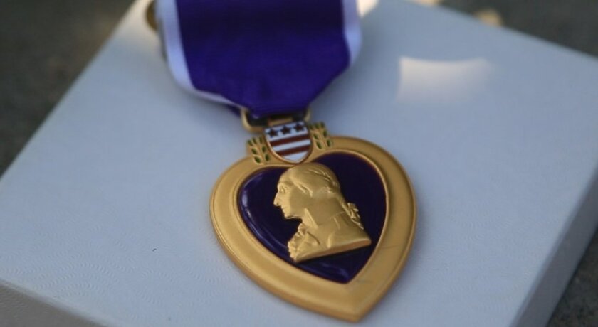 A Purple Heart was among items left at a memorial in downtown San Diego honoring slain police Officer Jonathan De Guzman.