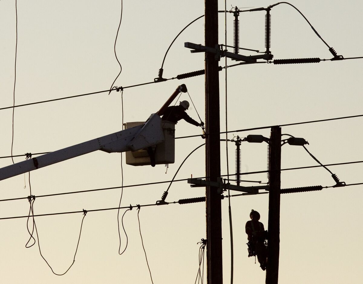 A San Diego Gas & Electric lineman works on a power line.