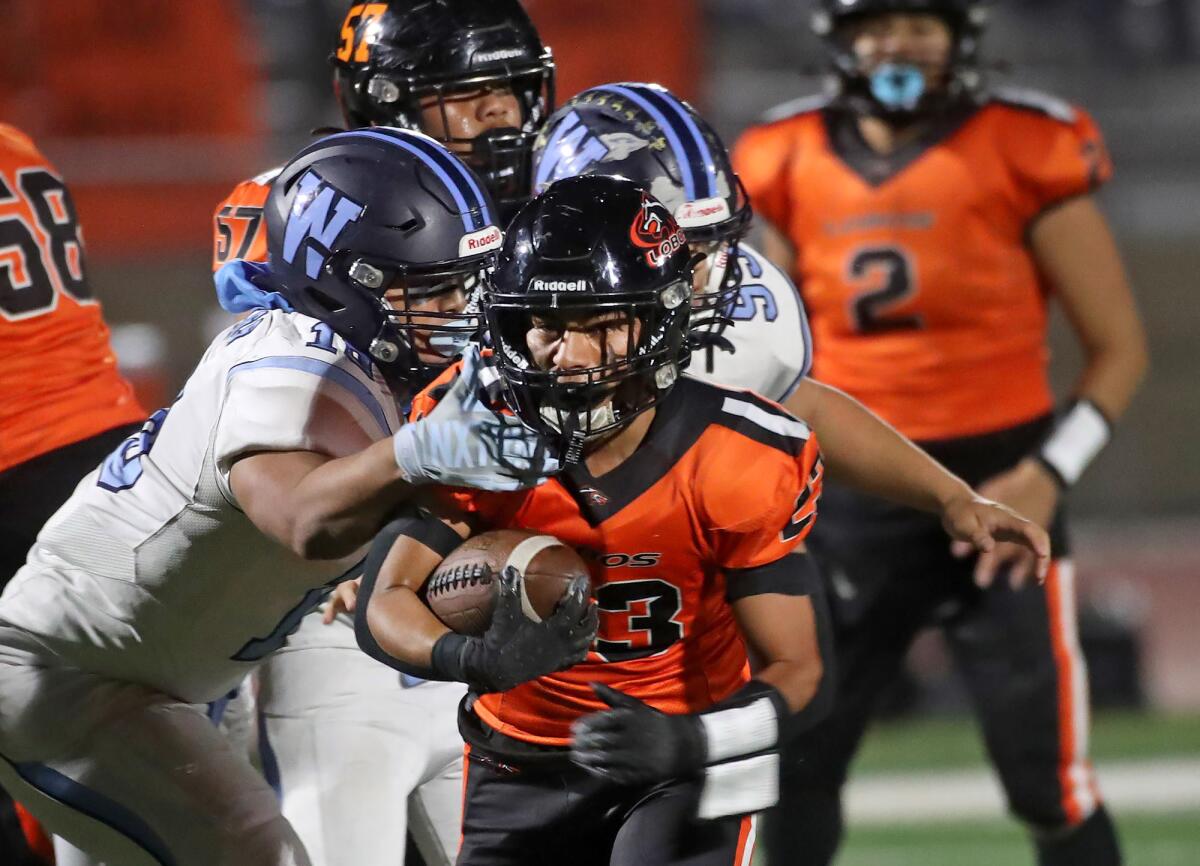 Pedro Hernandez (23) breaks tackles on a rushing attempt against Walnut on Friday.