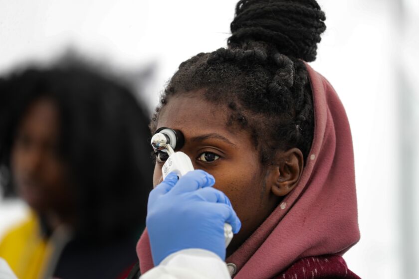 LOS ANGELES, CA - MARCH 19, 2020 - Precious Williams, 22, pregnant and suffering from cough and sore throat, is being checked at a screening station for COVID-19 set-up in Watts Health Center, Los Angeles.(Irfan Khan / Los Angeles Times)