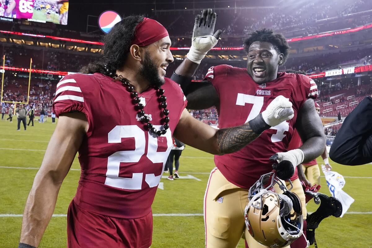 San Francisco 49ers safety Talanoa Hufanga (29) celebrates with offensive tackle Spencer Burford.