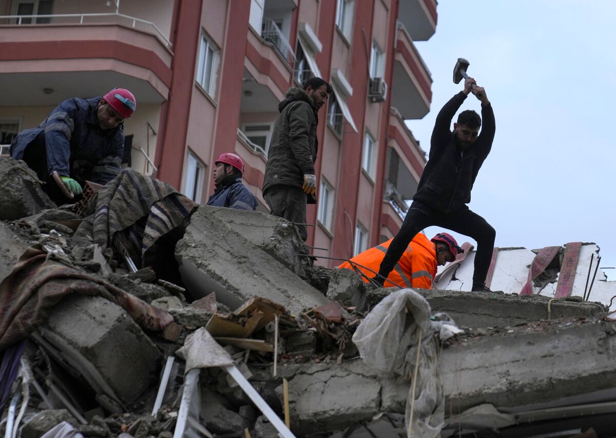Emergency workers searching for people in a destroyed building in Adana, Turkey