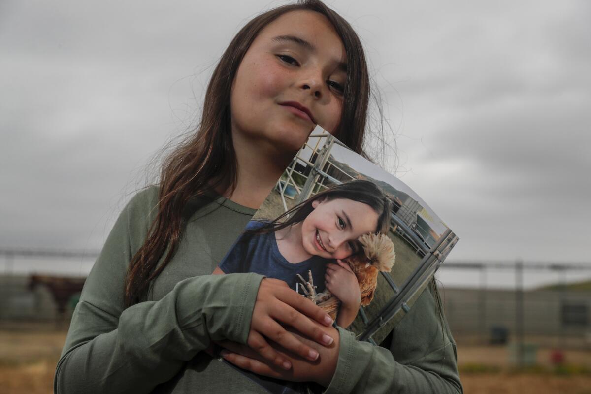 PERRIS, CA, THURSDAY, MAY 9, 2019 Jada Hand, 9, holds a photo of her pet chicken, Bambi, who was recently euthanized by State agents to prevent the spread of Newcastle Disease. (Robert Gauthier/Los Angeles Times)