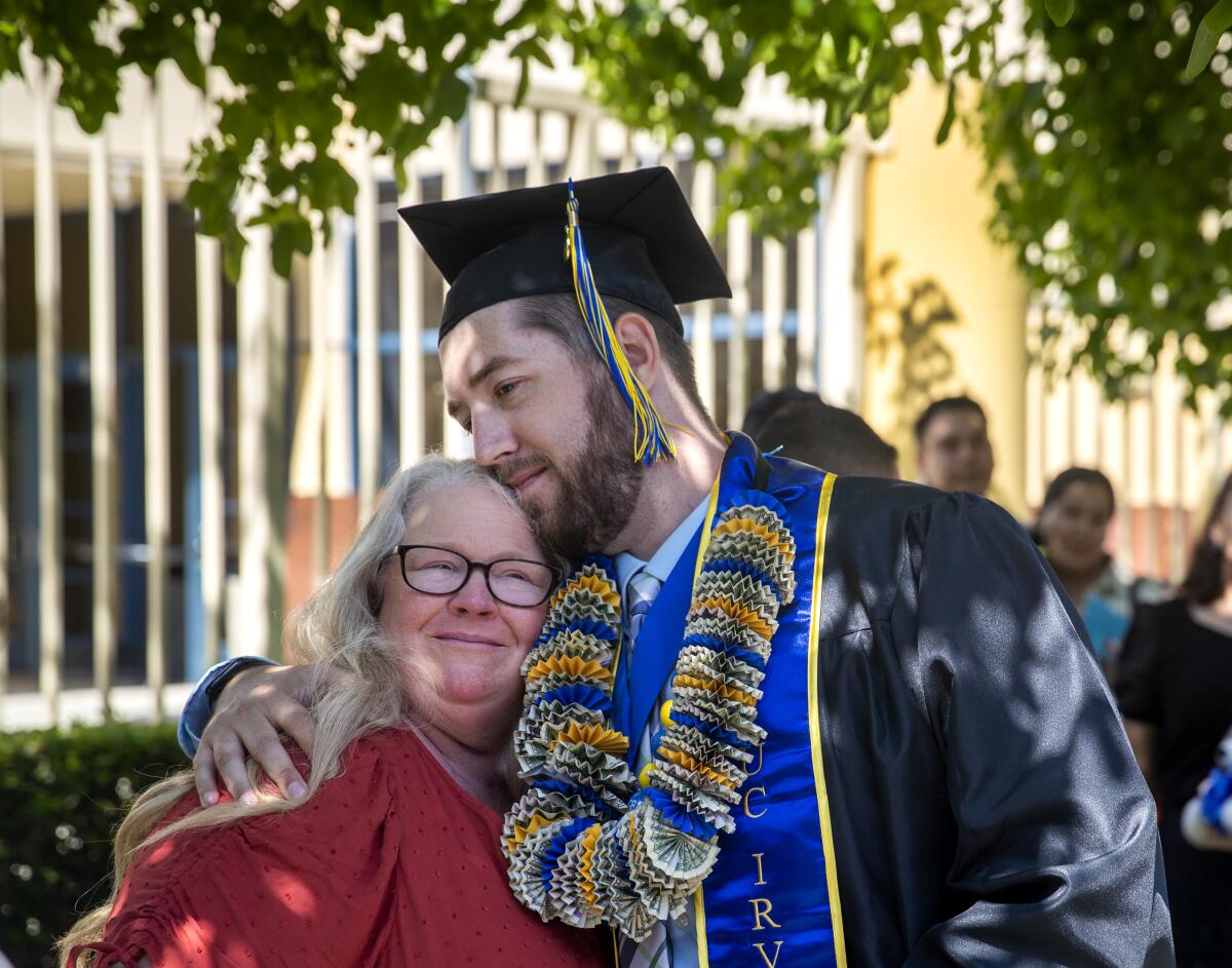 Irvine, CA - June 11: Patti Norman hugs her son, Andrew Norman, 29, of Rancho Cucamonga, after graduating
