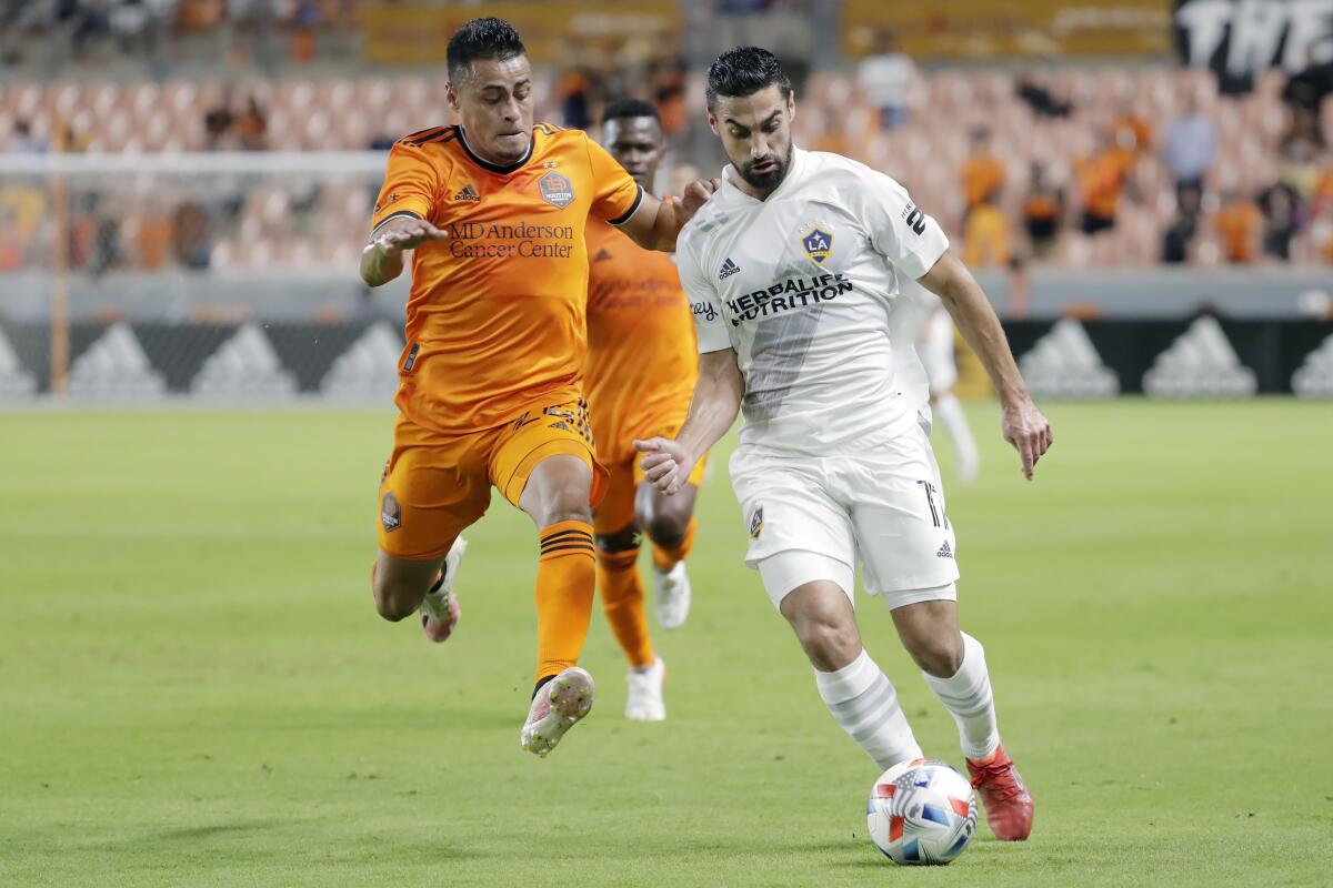 Galaxy midfielder Sebastian Lletget passes the ball in front of Houston Dynamo midfielder Darwin Cerén