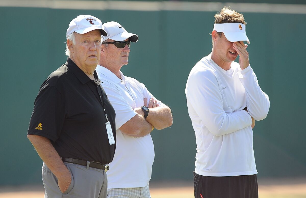 Former USC coach John Robinson, left, watches a USC practice session with ex-Cal coach Jeff Tedford, center, and ex-USC coach Lane Kiffin.