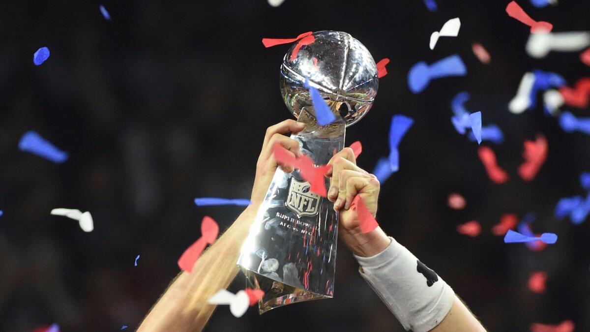 The Vince Lombardi Trophy is held aloft by New England quarterback Tom Brady after the Patriots defeated the Atlanta Falcons in Super Bowl 51 in February.