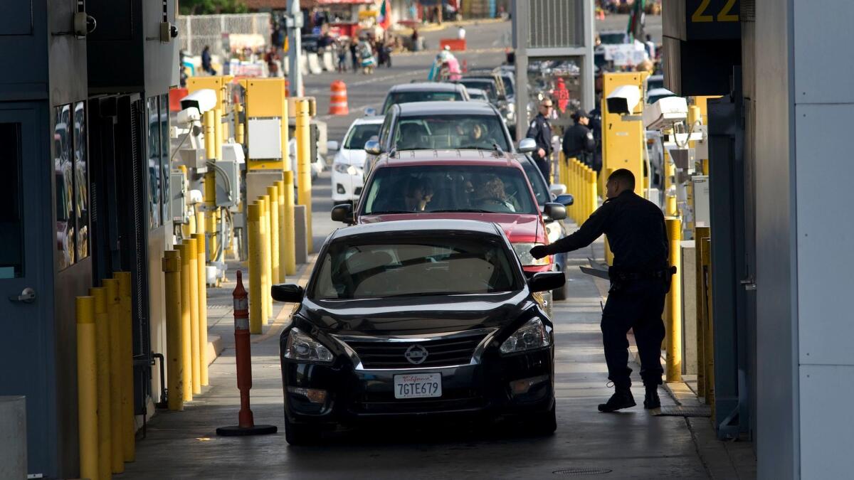 A U.S. Customs and Border Protection officer checks a driver's papers at the San Ysidro Port of Entry border crossing in San Diego on Feb. 10, 2016.