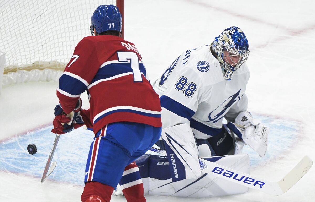 Montreal Canadiens' Kirby Dach (77) scores against Tampa Bay Lightning goaltender Andrei Vasilevskiy during the first period of an NHL hockey game Tuesday, March 21, 2023, in Montreal. (Graham Hughes/The Canadian Press via AP)