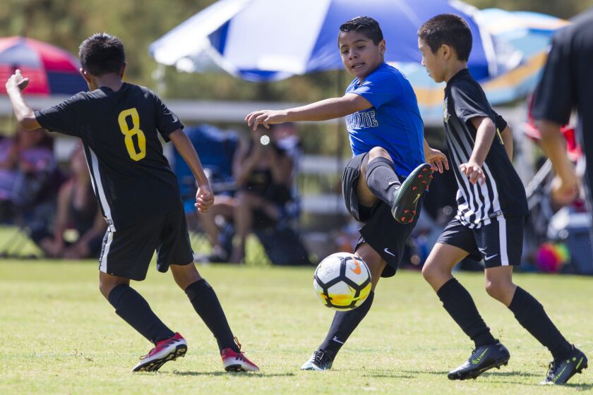 SAN DIEGO, August 5th, 2017 | 2017 Surf Cup U13 white division match between the Oceanside Breakers and Hawaii Excel at Surf Cup Sports Park in Del Mar. Oceanside's Eddie Salazar shoots between Hawaii defenders on an attempt to score in the second half. Chadd Cady for The San Diego Union-Tribune
