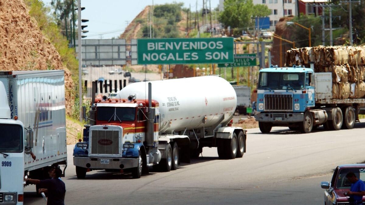 Northbound trucks wait to cross the border from Nogales, Mexico, to Nogales, Ariz.