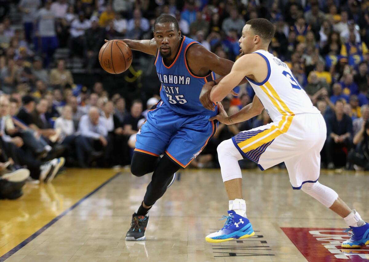 Thunder forward Kevin Durant (35) tries to dribble past Warriors guard Stephen Curry (30) Monday night at Oracle Arena.