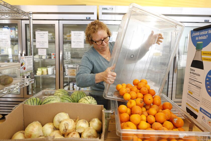 San Diego, CA - May 10: Volunteer Shelley Miller-Odelson stocks fresh fruit at the Jewish Family Service's Corner Market on Wednesday, May 10, 2023 in San Diego, CA. (K.C. Alfred / The San Diego Union-Tribune)