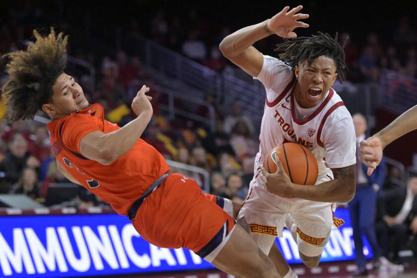 LOS ANGELES, CA - DECEMBER 18: Boogie Ellis #5 of the USC Trojans is fouled by Tre Donaldson.