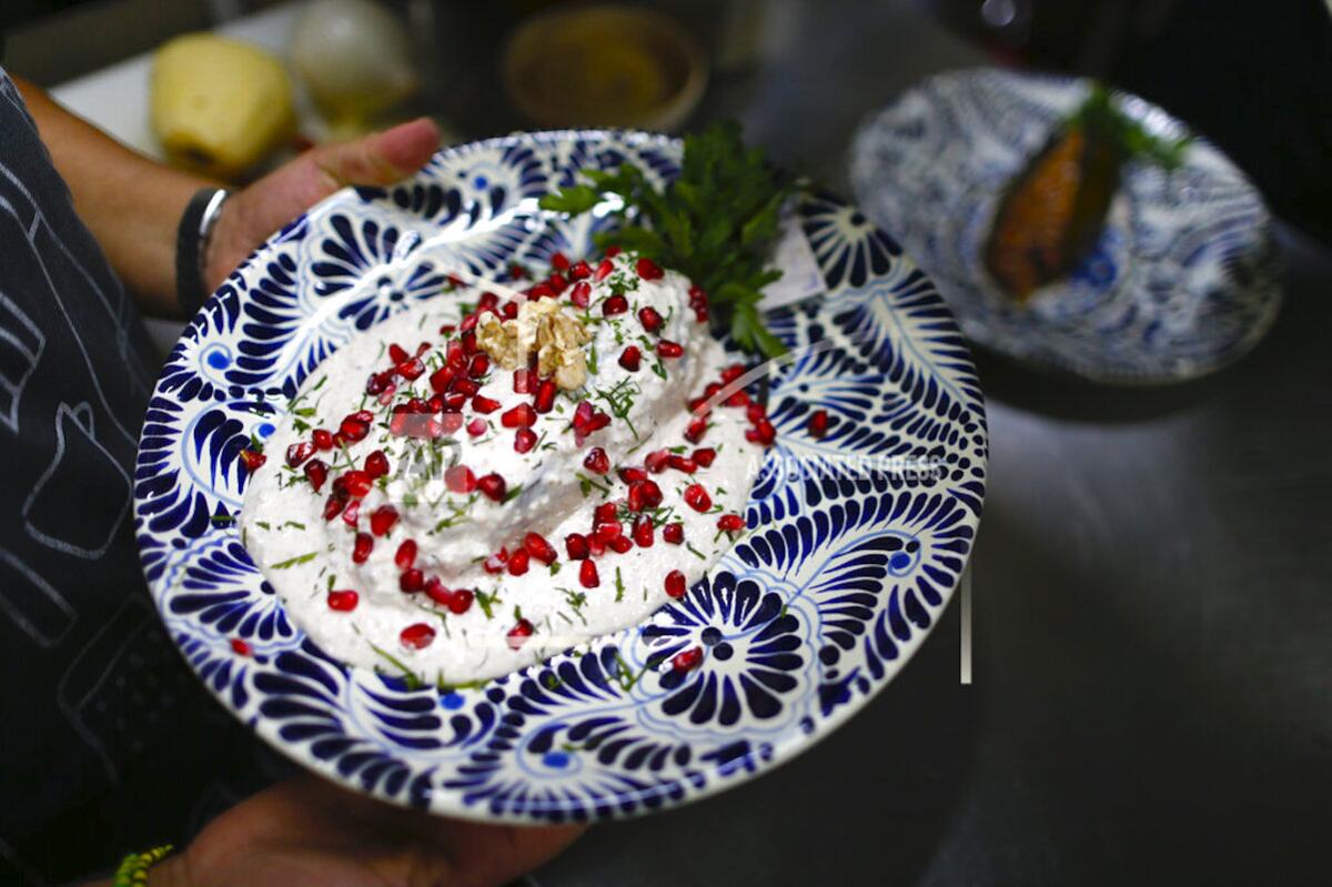 Una cocinera lleva un plato de chile en nogada a un restaurante de Ciudad de México.