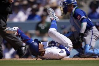 Los Angeles Dodgers' Mookie Betts, left, writhes on the ground after being hit by a pitch.