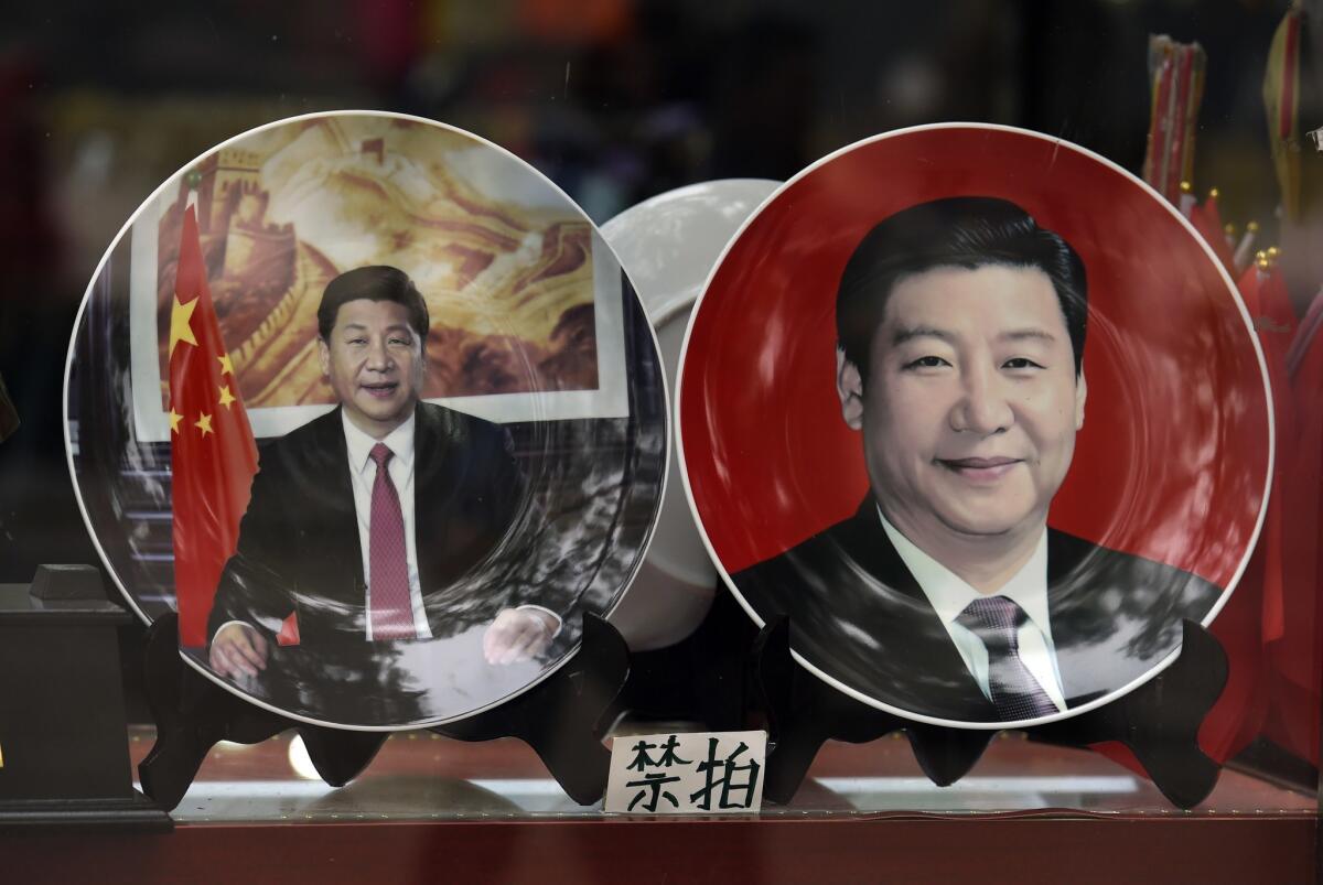 Decorative plates featuring Chinese President Xi Jinping are seen in a shop window in Beijing on Oct. 20.