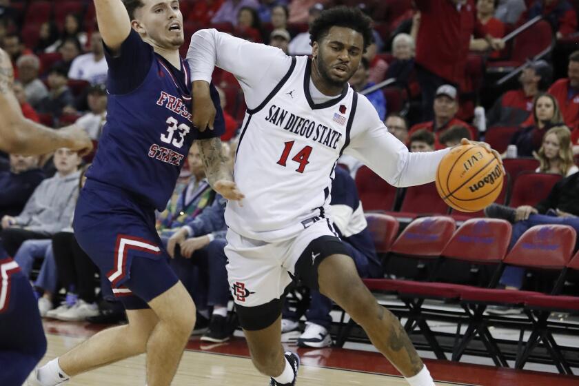 San Diego State guard Reese Waters drives against Fresno State's Steven Vasquez Jr. during the first half of an NCAA college basketball game in Fresno, Calif., Saturday, Feb. 24, 2024. (AP Photo/Gary Kazanjian)