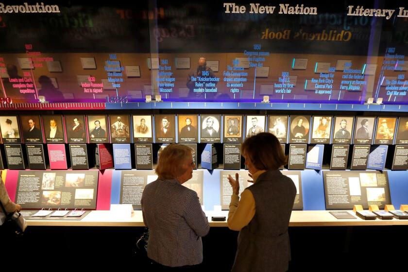 In this Monday, May 8, 2017 photo, visitors at the American Writers Museum look at a timeline display that celebrates authors who are emblematic of "American Voices", at the new museum in Chicago. (AP Photo/Charles Rex Arbogast)