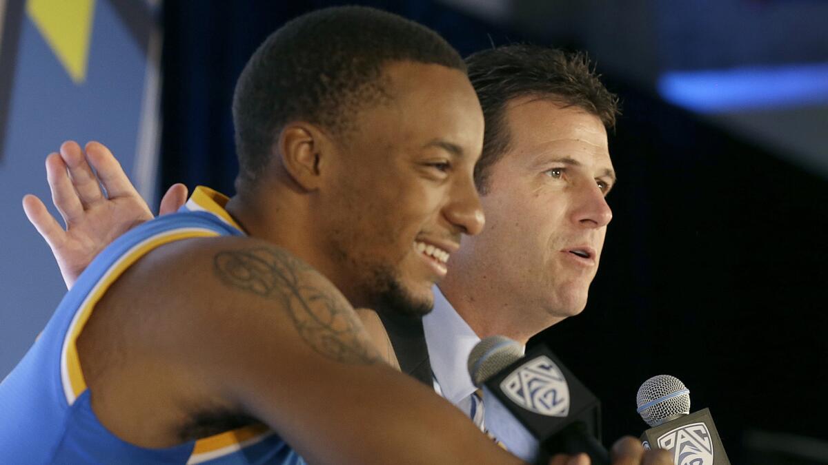 UCLA Coach Steve Alford, right, speaks while sitting next to a smiling Norman Powell at Pac-12 media day on Oct. 23.
