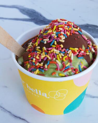 A cup of Dear Bella Creamery vegan ice cream with chocolate hard shell and rainbow sprinkles in Hollywood.