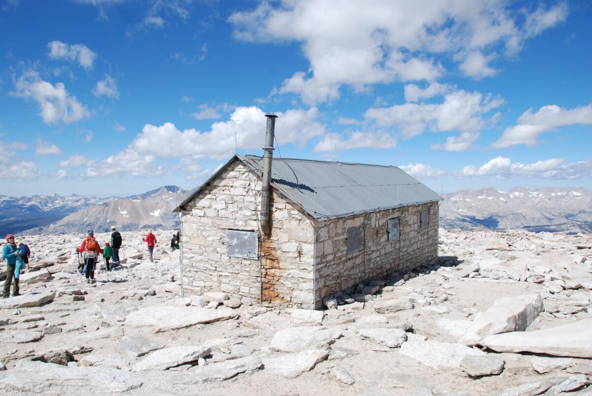 A small brick building at the top of a mountain.