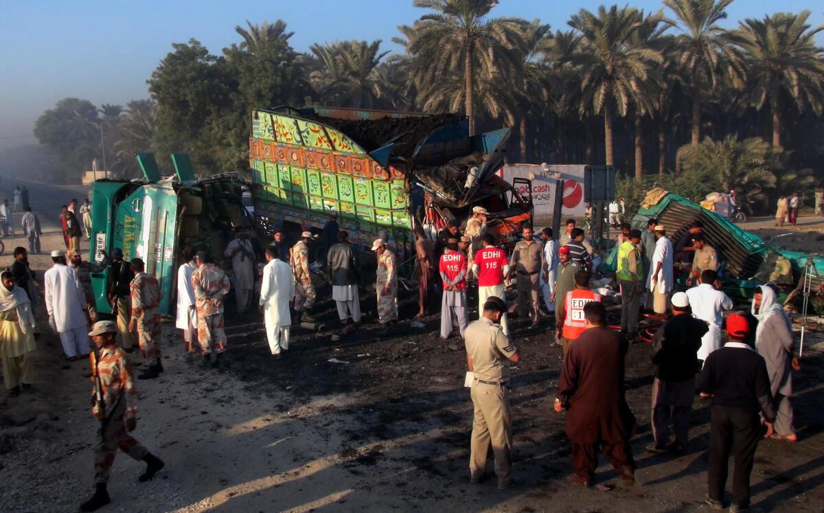 Pakistan paramilitary soldiers and rescue workers gather at the site of a bus and truck collision in Pakistan's Khairpur district on Tuesday.
