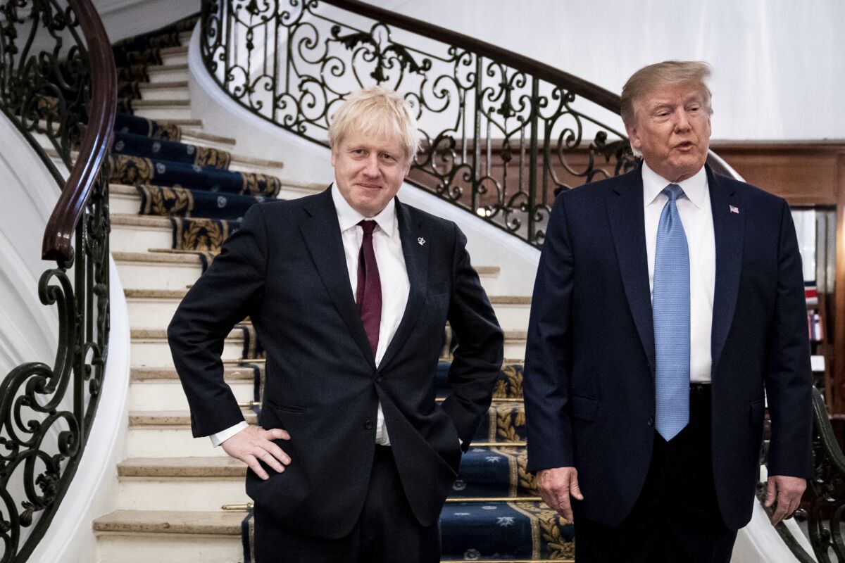 FILE - In this Sunday, Aug. 25, 2019 file photo President Donald Trump and Britain's Prime Minister Boris Johnson, left, speak to the media before a working breakfast meeting at the Hotel du Palais on the sidelines of the G-7 summit in Biarritz, France. British Prime Minister Boris Johnson has said a lot of nice things about Donald Trump over the years, from expressing admiration for the U.S. president to suggesting he might be worthy of the Nobel Peace Prize. But after a mob of Trump supporters invaded the U.S. Capitol on Jan. 6, Johnson has changed his tune.(Erin Schaff, Pool via AP)