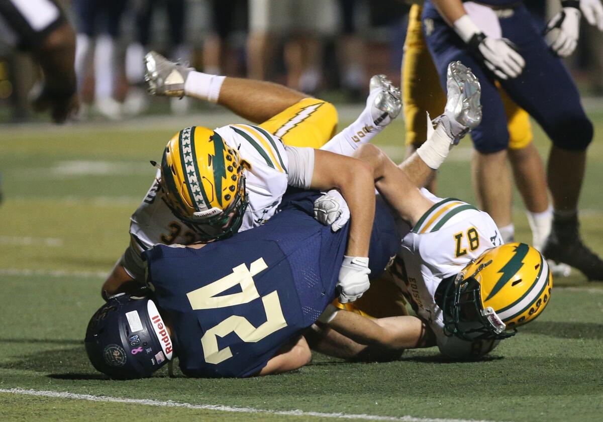 Edison High middle linebacker Luke Hoggard (33) tackles San Juan Hills running back Chase Monarch (24) for a loss in the first round of the CIF Southern Section Division 2 playoffs on Nov. 2, 2018.