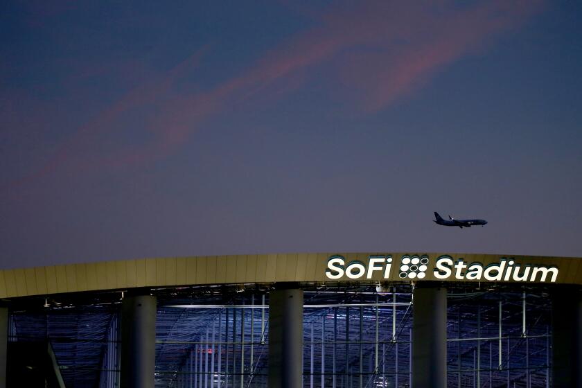 INGLEWOOD, CALIF. - FEB. 2, 2022. A plane making an approach to Los Angeles International Airport flies over SoFi Stadium in Inglewood, site of Super Bowl LVI on Feb. 13, 2022. (Luis Sinco / Los Angeles Times)