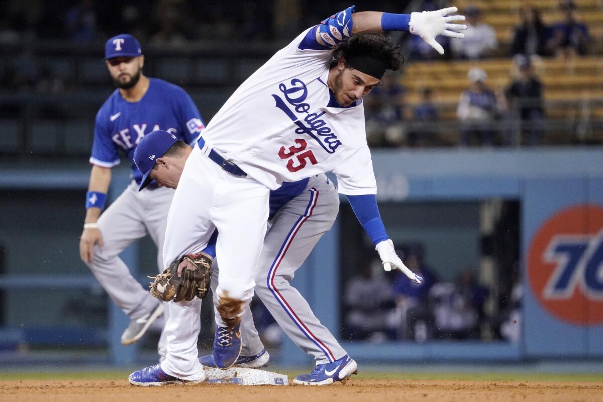 Los Angeles Dodgers' Cody Bellinger, right, is tagged out at second by Texas Rangers second baseman Nick Solak after trying to stretch a single into a double during the fourth inning of a baseball game Friday, June 11, 2021, in Los Angeles. (AP Photo/Mark J. Terrill)
