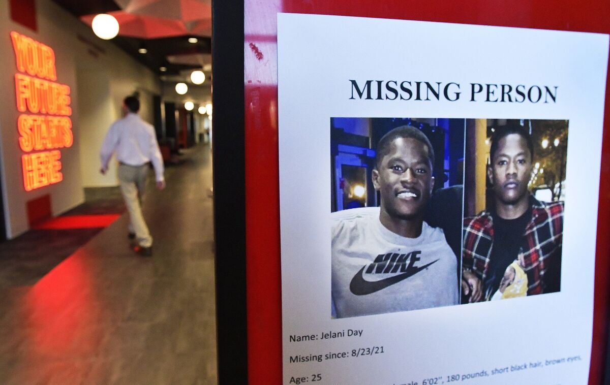 Illinois State University students walk past a poster seeking the whereabouts of Jelani Day near the Dean of Students office in Illinois State University's Bone Student Center in Normal, Illinois, Thursday, Sept. 23, 2021. Day's body washed up on the banks of the Illinois River near Peru, Illinois, on Sept. 4, 2021. Civil rights attorney Ben Crump has joined Jelani Day’s mother to demand the FBI take charge of an investigation into why the Illinois State University graduate student disappeared in August and was later found dead in a river.(David Proeber/The Pantagraph via AP)