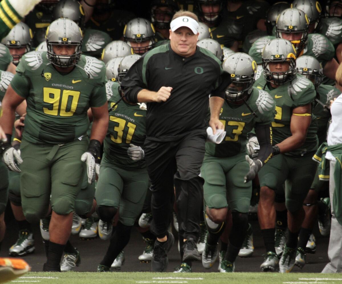Former coach Chip Kelly and the Oregon Ducks, shown in 2011, received minor penalties from the NCAA on Wednesday for recruiting violations.