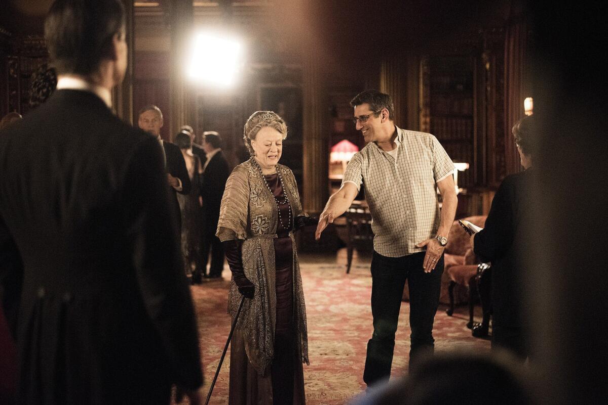 A woman in costume alongside a man on a regal film set.