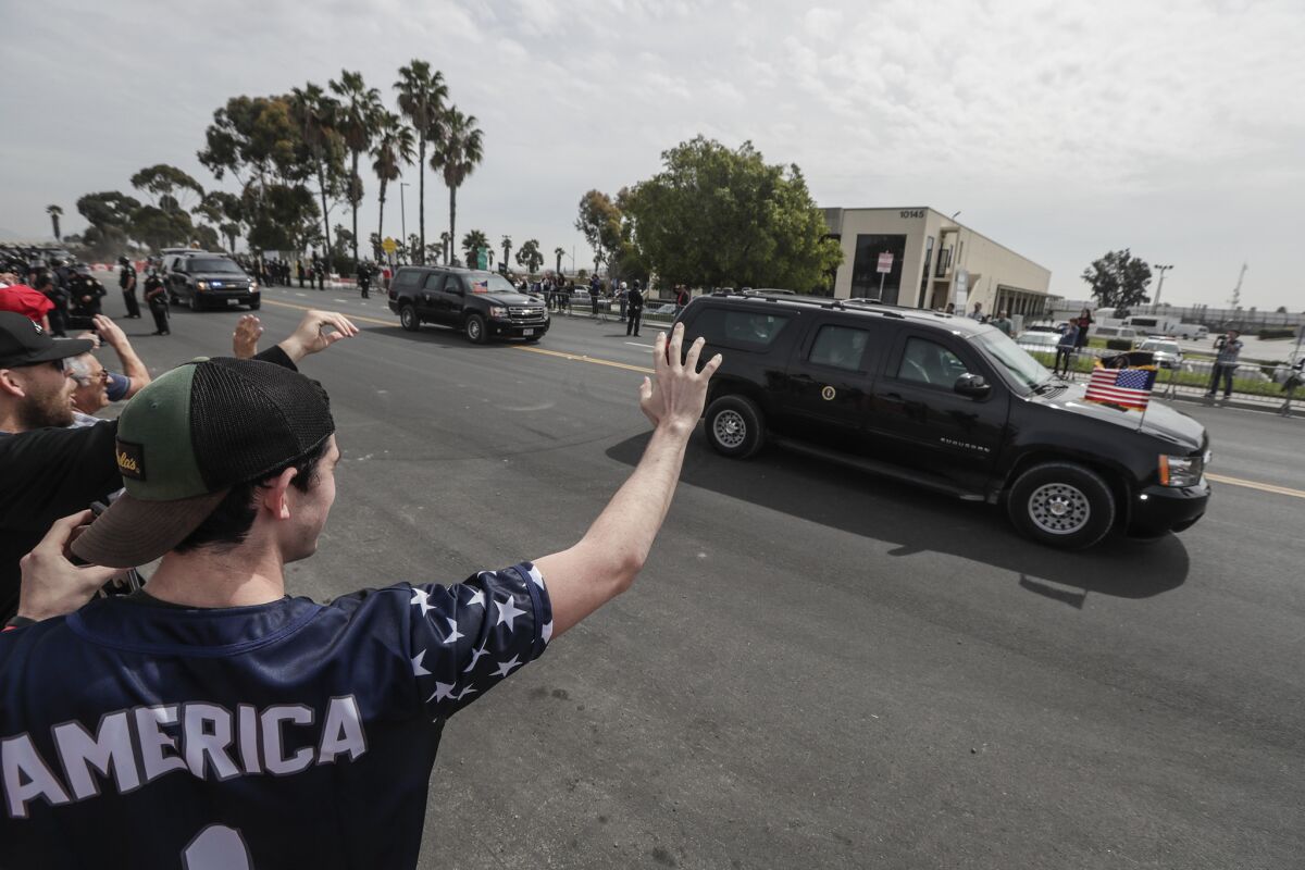 Supporters of President Trump wave as his motorcade passes by near the border in San Diego.