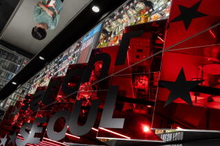 Mirrors reflect people shopping and eating at a GS25 convenience store.