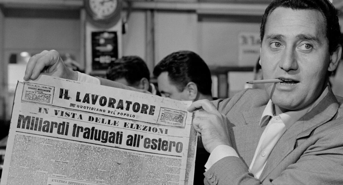 black and white photo of a man smoking a cigarette and holding up an Italian restaurant 