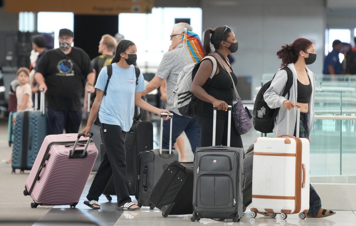 Travelers walk through an airport terminal.