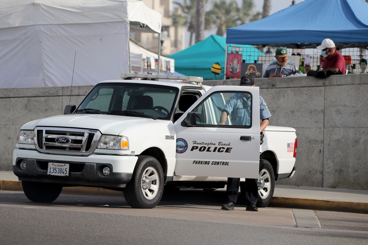 A Huntington Beach Police Parking Control officer exits his truck on Friday.