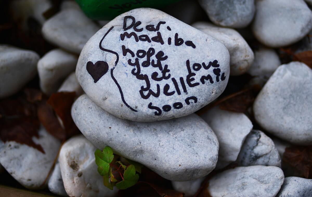 A stone painted with a get-well message and left outside former South African President Nelson Mandela's residence in the Houghton area of Johannesburg on Wednesday. Mandela is known as Madiba.