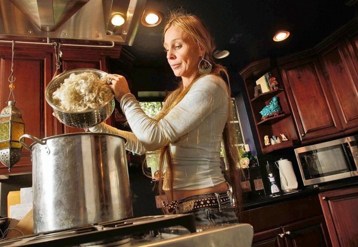 Natalie Redding transfers washed wool into a pot to dye. Her Namaste Farms yarns are more expensive than some but are selling well.