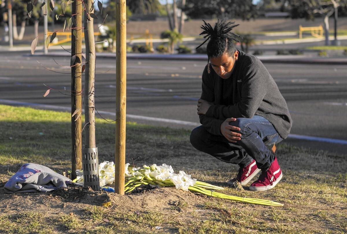 Bryan Aguilar looks at a memorial in Costa Mesa for Bryan Torres, who was stabbed to death during a fight at a party in Santa Ana last weekend.