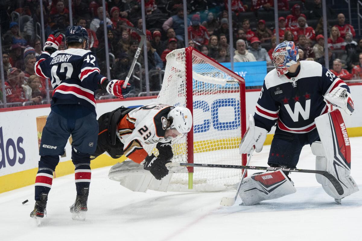 Ducks center Mason McTavish hits the post as he is checked by Capitals defenseman Martin Fehervary in the second period.