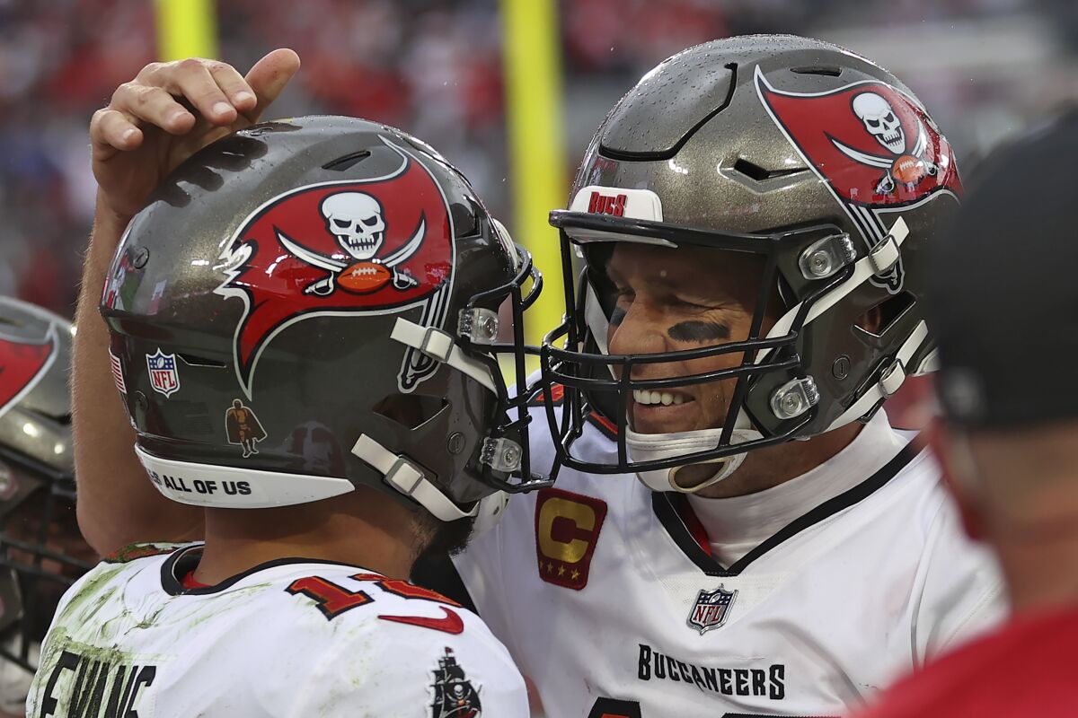 Tampa Bay Buccaneers quarterback Tom Brady, right, celebrates with wide receiver Mike Evans after Evans caught a touchdown pass against the Philadelphia Eagles during the second half of an NFL wild-card football game Sunday, Jan. 16, 2022, in Tampa, Fla. (AP Photo/Mark LoMoglio)