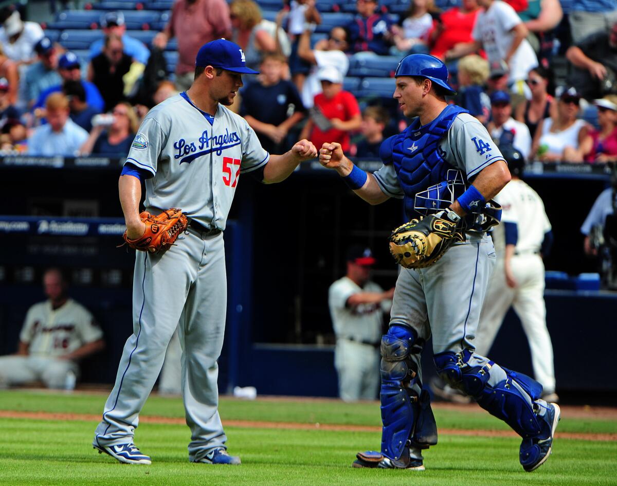 Scott Elbert, left, and A.J. Ellis celebrate a victory over the Atlanta Braves on Aug. 19.