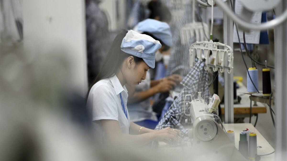 Workers stitch apparel in a factory in Hanoi.