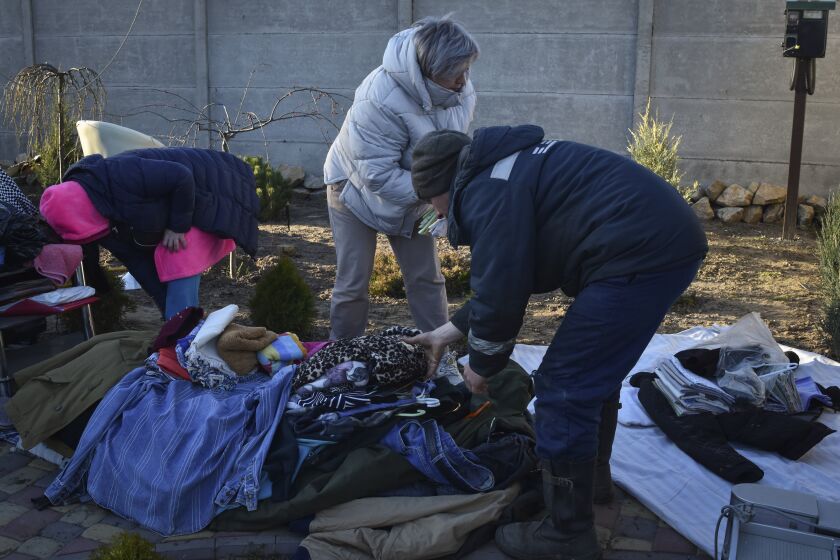 People gather their belongings from the building which was destroyed as a result of Russian strike in Zaporizhzhia district, Ukraine, Friday, March 31, 2023. (AP Photo/Andriy Andriyenko)