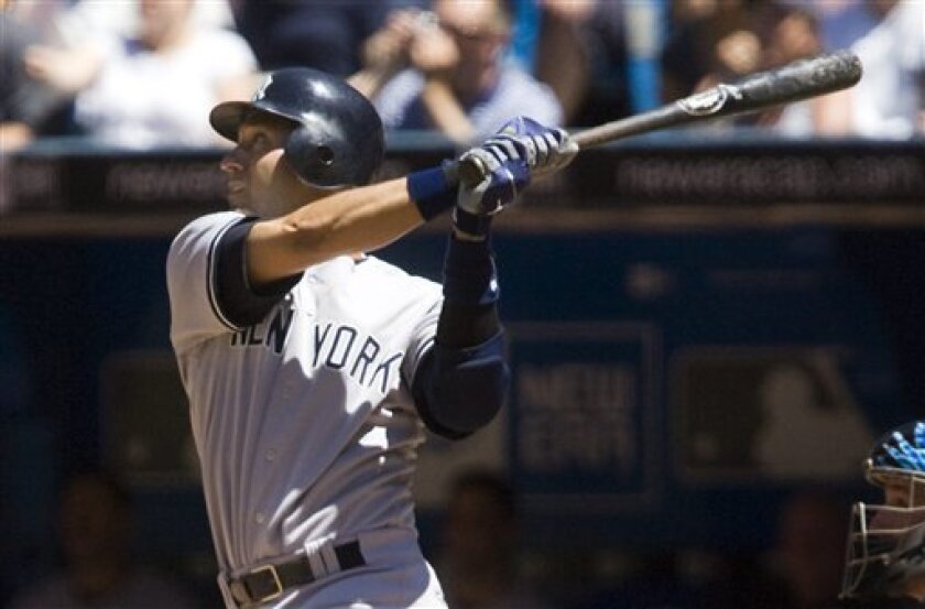 New York Yankees shortstop Derek Jeter hits a two-run home run against the Toronto Blue Jays in the fifth inning of their AL baseball game in Toronto Saturday, June 5, 2010.(AP Photo/The Canadian Press,Adrien Veczan)
